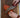 A Cardinal Red Chef Knife Cutting an Heirloom Tomato on Rustic Wood Board on Marble Countertops