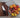 A Grey Chef Knife with a Waffle Striped Navy Kitchen Towel, a Bowl of mixed onion, shallot, tomatoes and citrus, a chef knife for women, on a wood cutting board on a marble countertop
