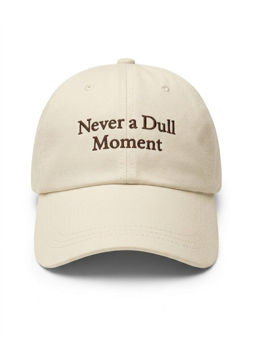 Beige cap with 'Never a Dull Moment' text on a white background