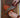 A Cardinal Red Chef Knife Cutting an Heirloom Tomato on Rustic Wood Board on Marble Countertops