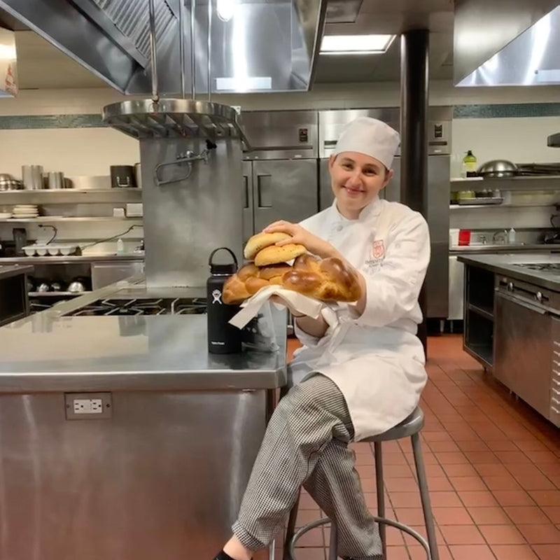 Chef holding bread in a professional kitchen