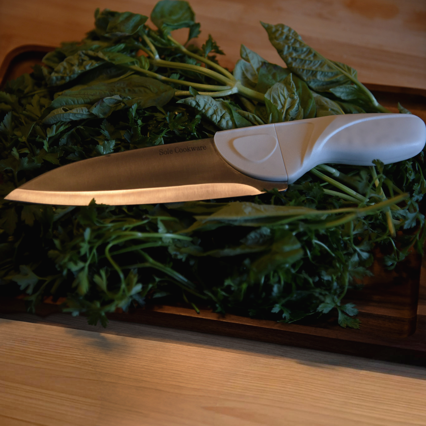 Cream Knife on a pile of green leafy vegetables on a wooden surface