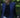 Lightweight Navy Vest for Kitchen use, water repellent, navy closure. Pictured in a lawn grass beautiful and a girl standing in white pants, a navy sweater and a simple necklace
