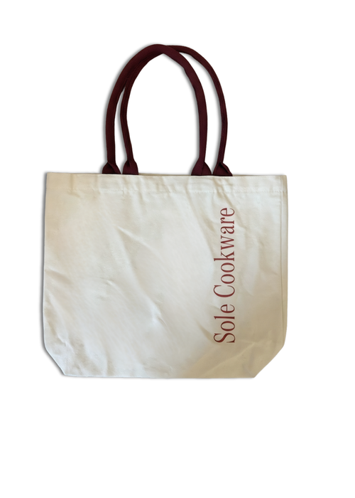 Beige tote bag with brown handles and 'Sole Cookware' text on a white background